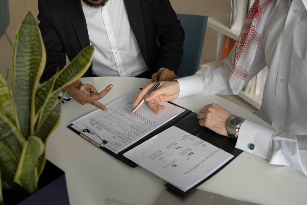Deux professionnels analysant des documents stratégiques lors d’une réunion pour un accompagnement de votre projet entrepreneurial