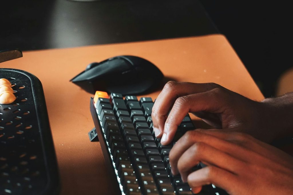 Mains tapant sur un clavier mécanique, symbolisant le travail de préparation à la création d’entreprise