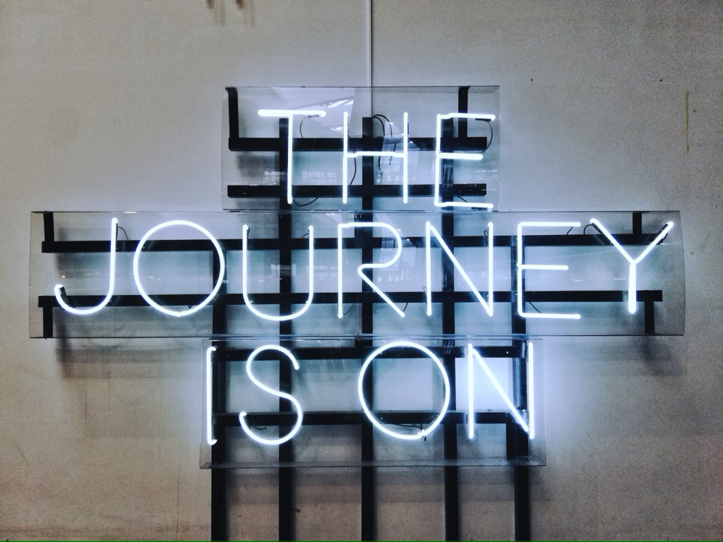 Enseigne lumineuse affichant “The journey is on”, symbolisant le début d’un projet entrepreneurial